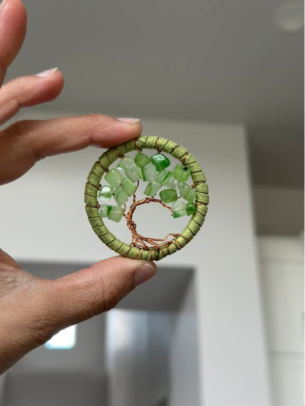 handmade wire-wrapped tree of life pendant featuring green gemstone